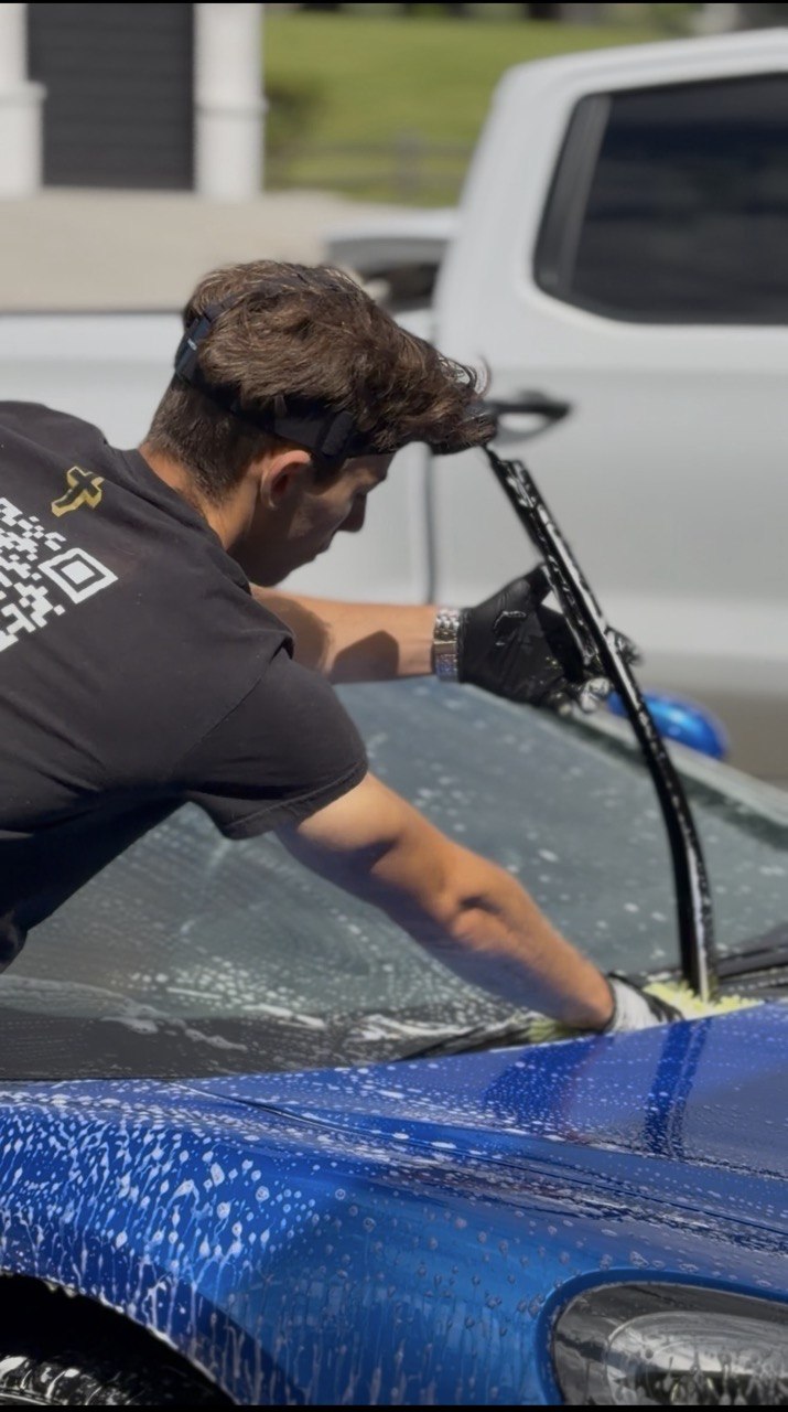 David hand washing a blue sports car in Spokane